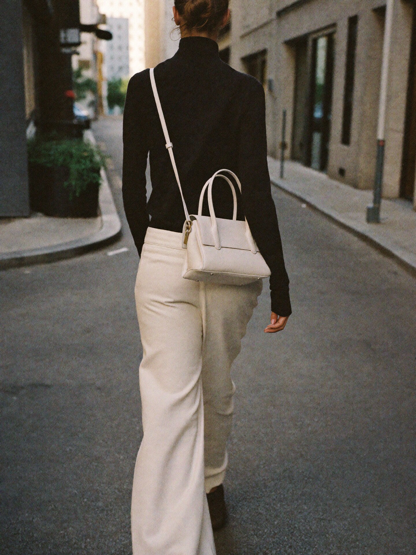 Woman crossbody NYC carrying The Mini Slouch cream nylon by Bowryn — compact crossbody handbag