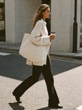 Woman walking in NYC carrying The Tote cream nylon by Bowryn — premium handbag designed for modern life