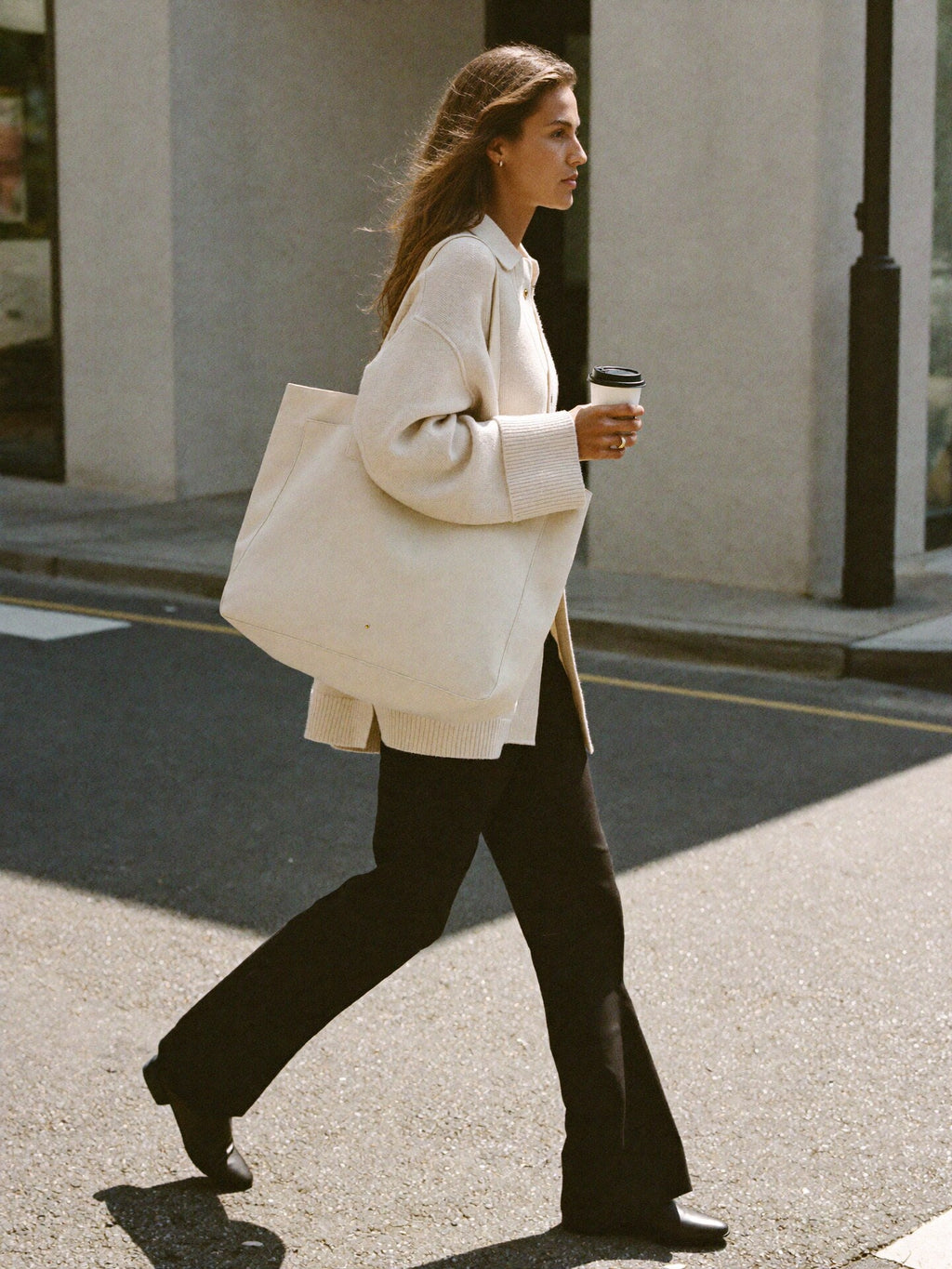 Woman walking NYC golden hour carrying Bowryn The Tote in Olive premium nylon