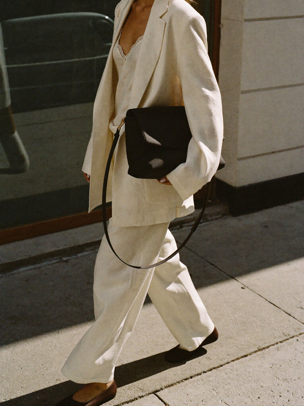 Woman walking NYC sunny morning carrying The Shoulder Bag cream nylon by Bowryn — premium crossbody handbag