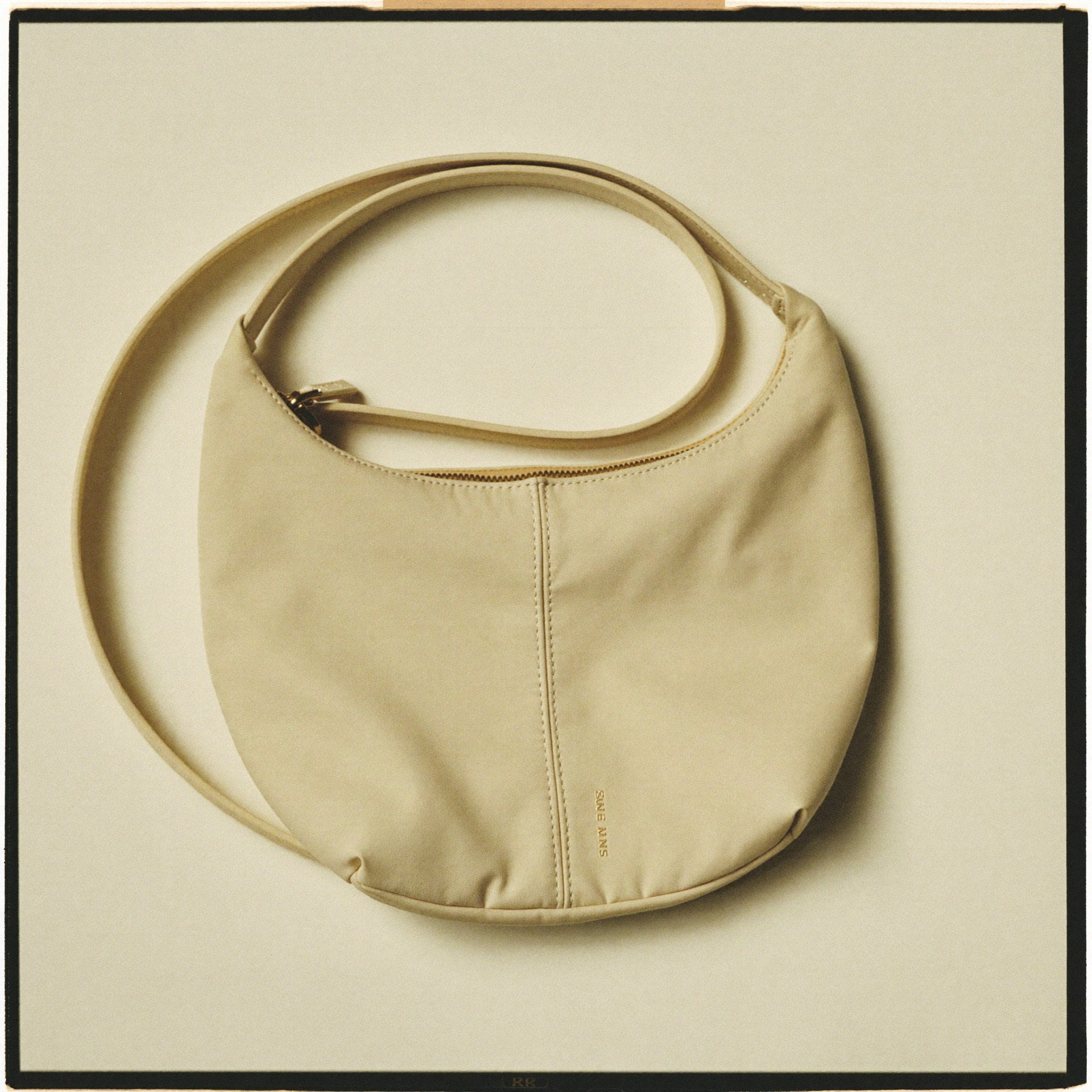 The Mini Slouch front view — premium cream nylon Bowryn compact crossbody