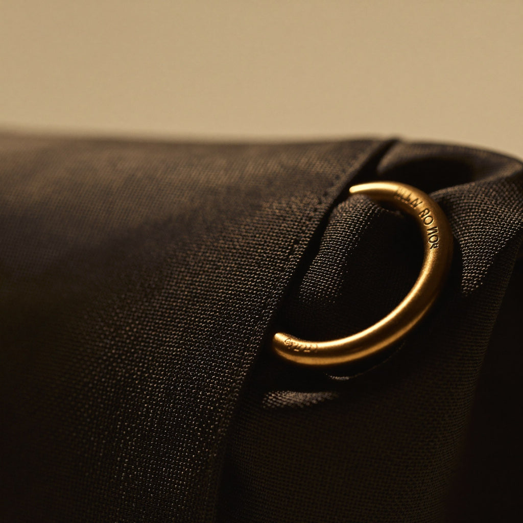 Macro detail of brass-finish hardware and premium technical nylon weave