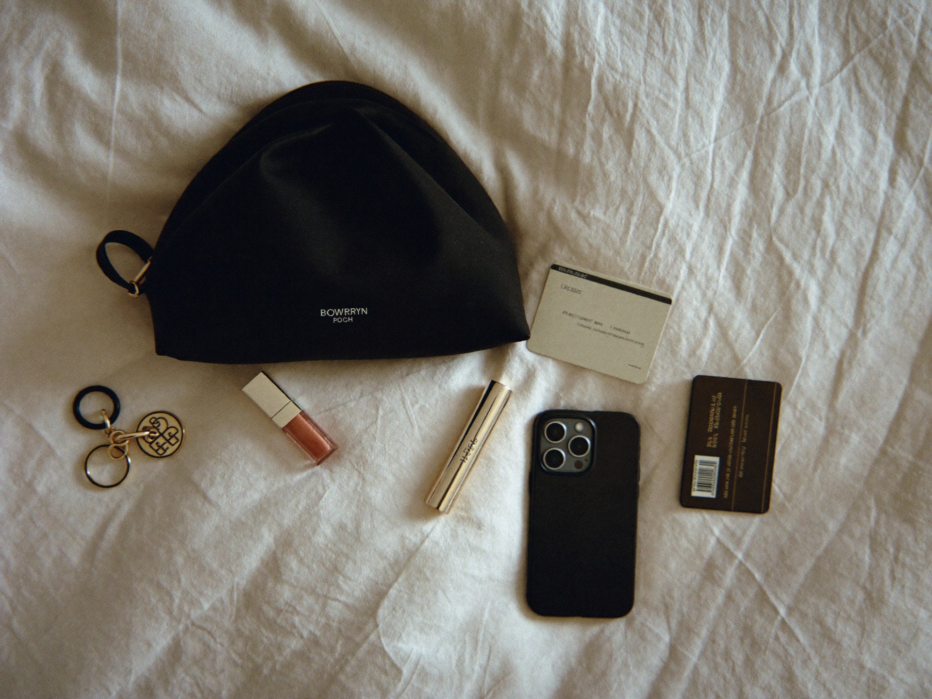 The Pouch evening flat lay with lipstick, iPhone, keys, credit cards