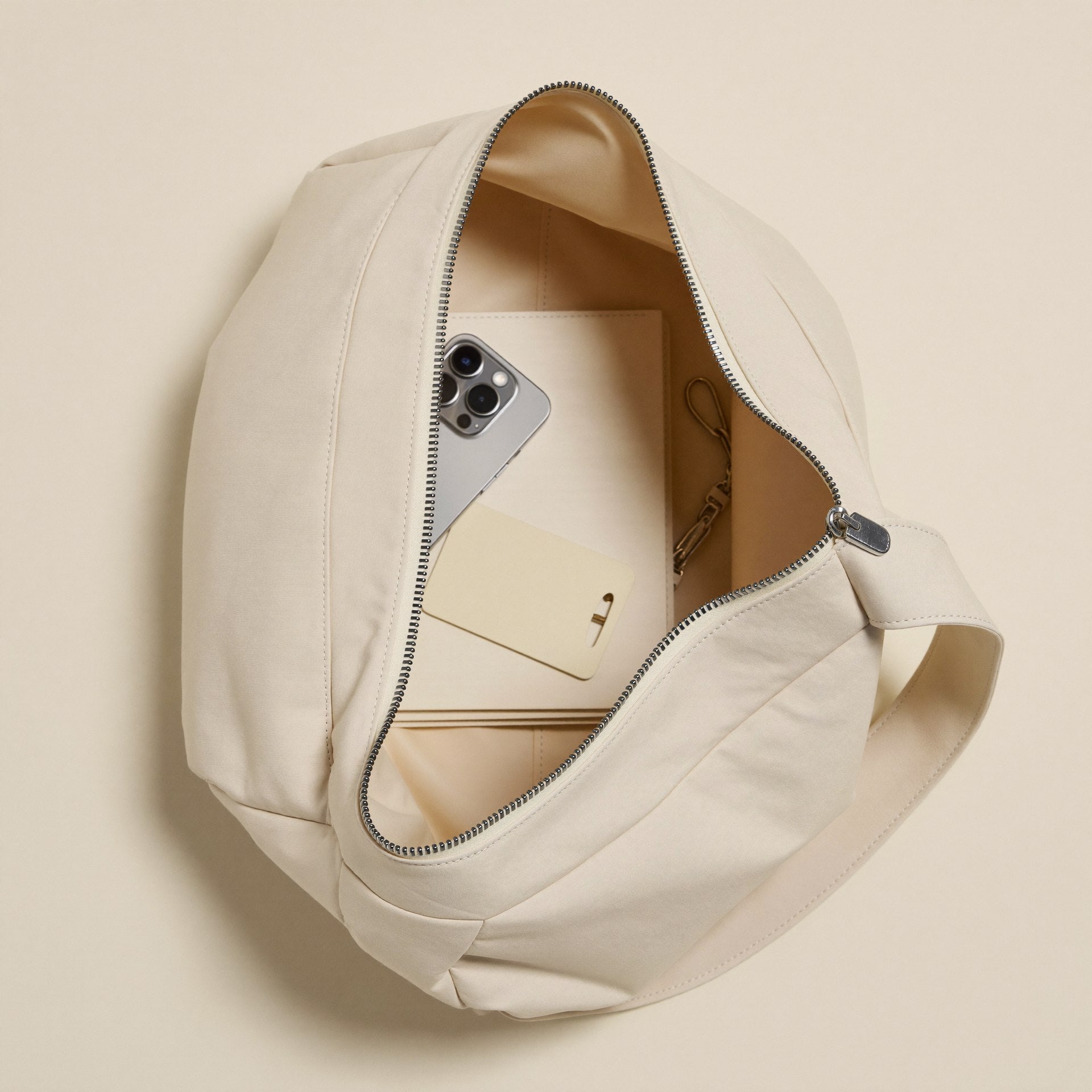 The Mini Slouch open showing minimalist essentials — phone, card, keys