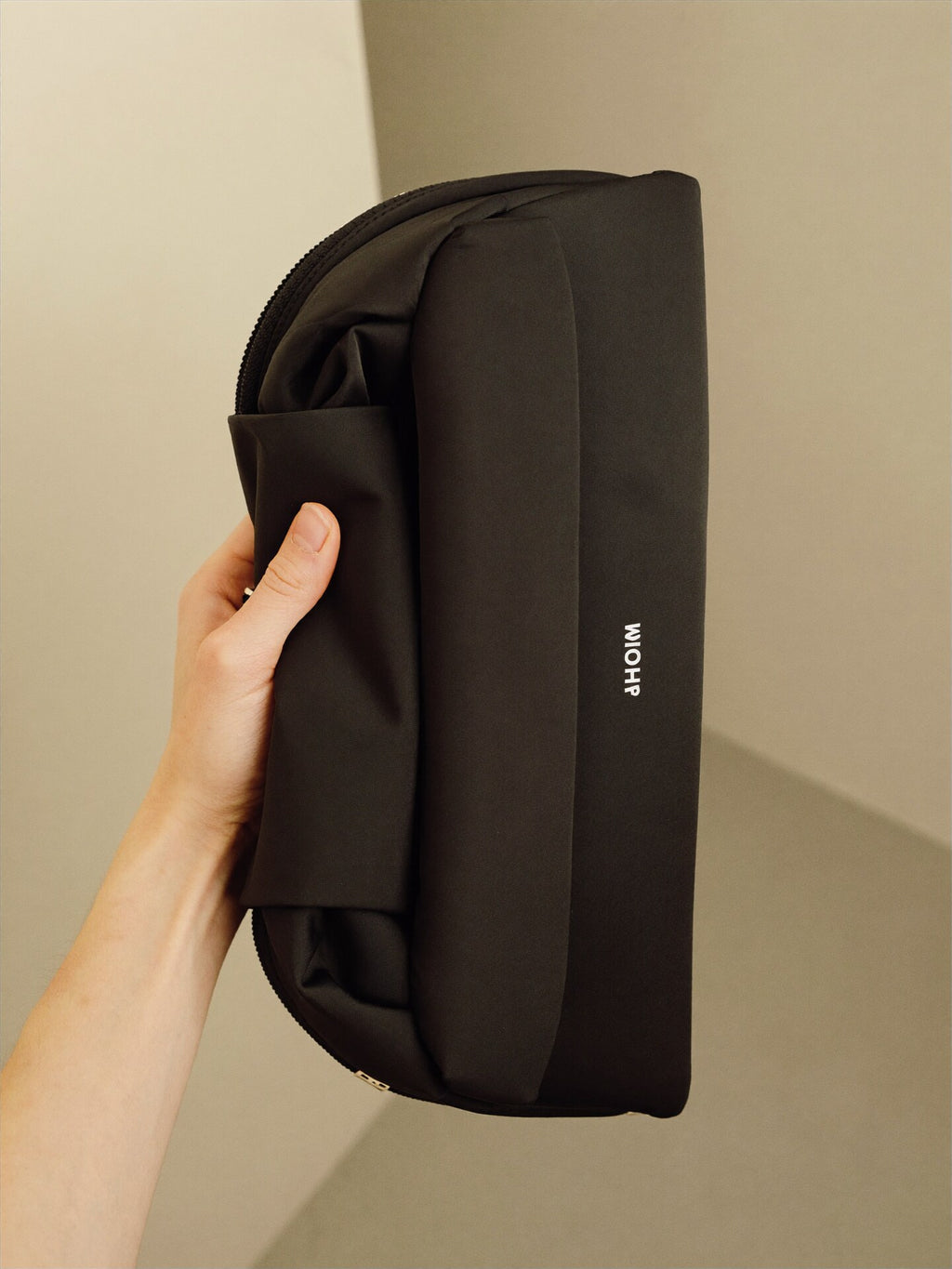 The Pouch hand scale reference showing compact size