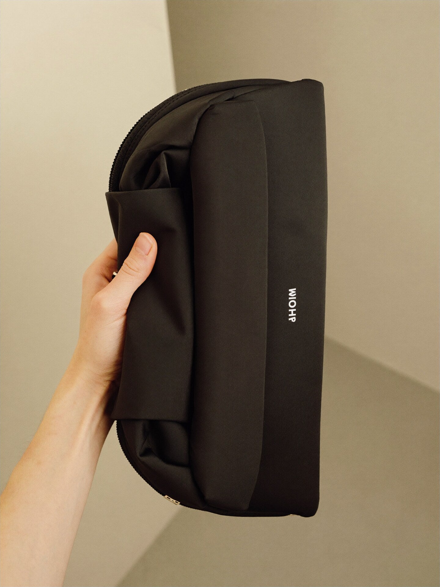 The Pouch hand scale reference showing compact size