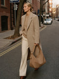 Woman walking NYC fall golden hour carrying The Slouch in Camel premium nylon by Bowryn — warm beige editorial