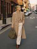Woman walking NYC fall golden hour carrying The Tote in Olive premium nylon by Bowryn — warm beige editorial